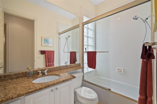 full bathroom with shower / bath combination with glass door, vanity, and toilet