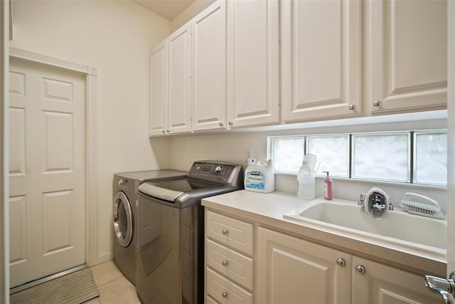 clothes washing area featuring cabinets, independent washer and dryer, sink, and light tile patterned floors