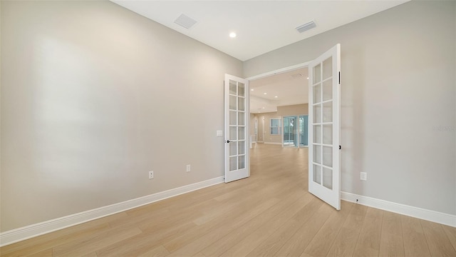 empty room featuring french doors and light wood-type flooring