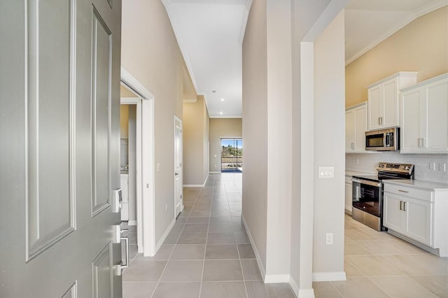 corridor featuring light tile patterned floors and ornamental molding