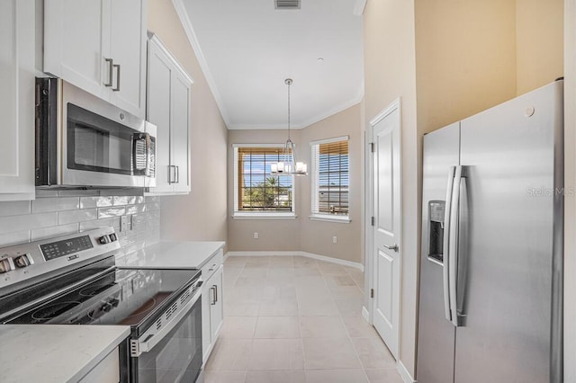 kitchen featuring pendant lighting, backsplash, white cabinets, light tile patterned floors, and appliances with stainless steel finishes