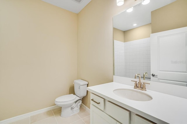 bathroom featuring tile patterned floors, vanity, a tile shower, and toilet