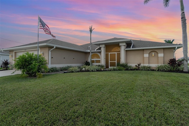 view of front of home with a garage and a yard