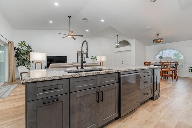 kitchen featuring light hardwood / wood-style floors, a kitchen island with sink, sink, vaulted ceiling, and ceiling fan