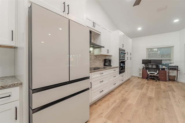 kitchen featuring white cabinets, light wood-type flooring, backsplash, black appliances, and light stone countertops