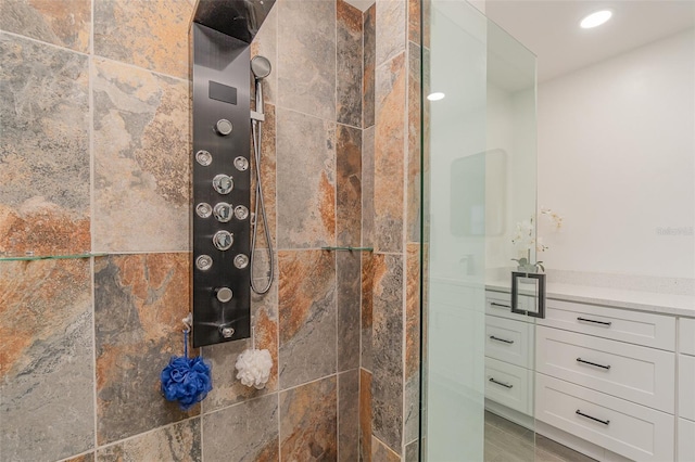 bathroom with a shower with door and vanity