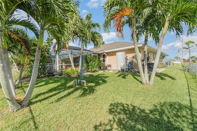 rear view of property featuring a lanai and a yard