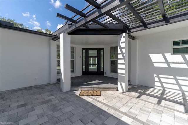 entrance to property featuring a patio and a pergola