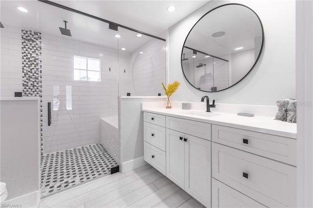 bathroom with tiled shower and vanity