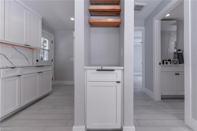 kitchen with light wood-type flooring and white cabinetry