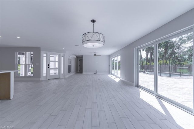 unfurnished living room with ceiling fan and hardwood / wood-style flooring