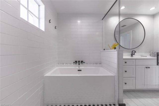 bathroom featuring vanity and separate shower and tub