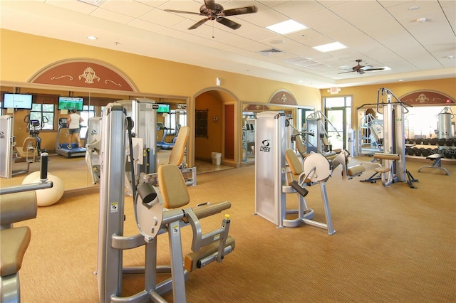 exercise room featuring ceiling fan, a paneled ceiling, and light carpet