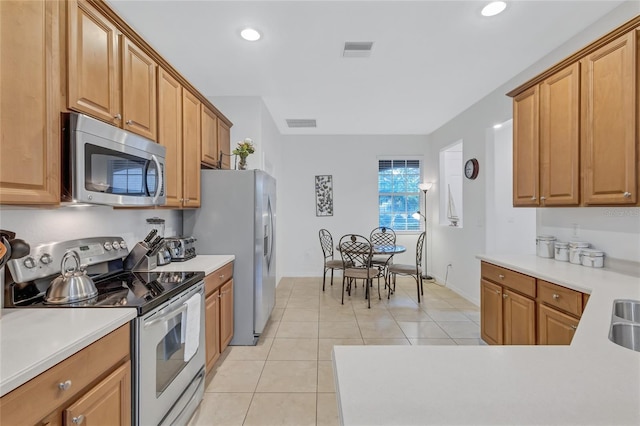 kitchen featuring light tile patterned flooring and stainless steel appliances