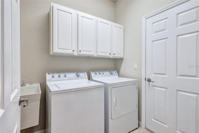 clothes washing area featuring washing machine and clothes dryer and cabinets