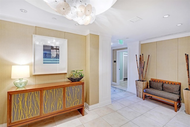 hallway with ornamental molding, light tile patterned floors, and a notable chandelier