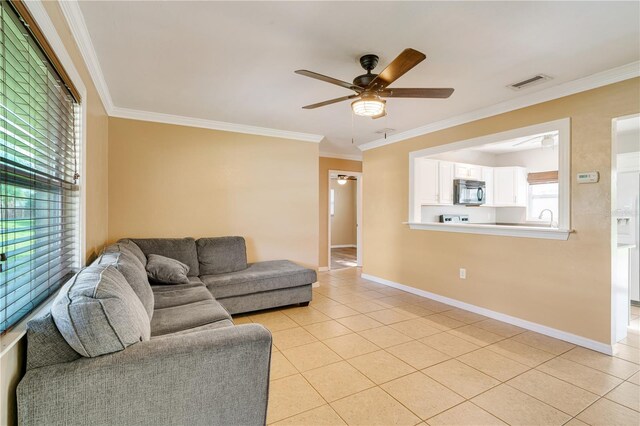 tiled living room with ceiling fan, crown molding, and sink