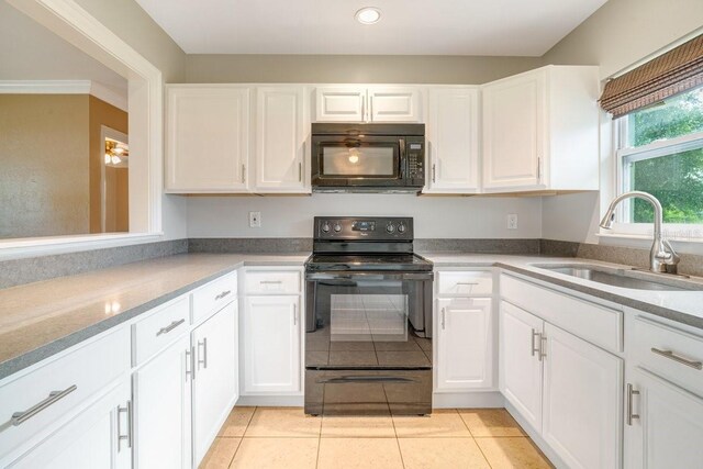 kitchen featuring black appliances, light tile patterned flooring, sink, and white cabinets