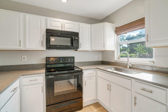 kitchen featuring light tile patterned floors, white cabinets, sink, and black appliances