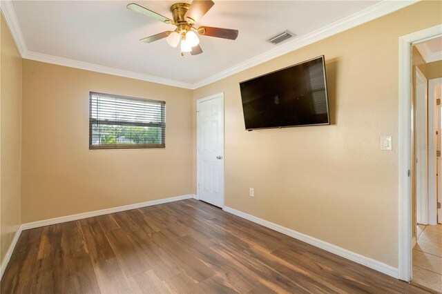 unfurnished room featuring ceiling fan, hardwood / wood-style flooring, and crown molding