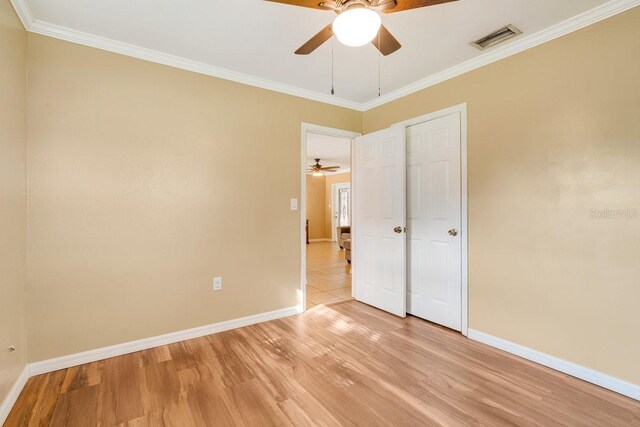 unfurnished bedroom with crown molding, ceiling fan, and light hardwood / wood-style flooring