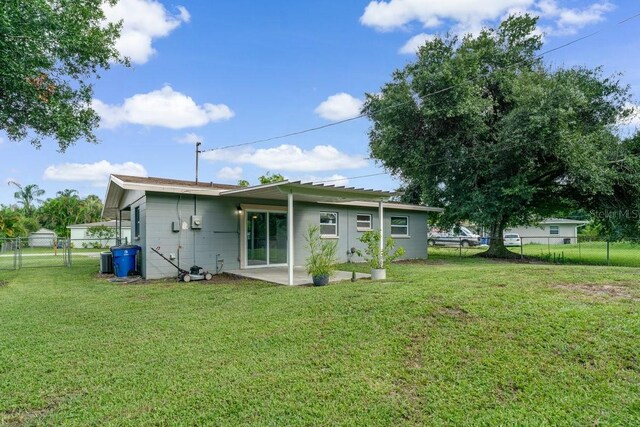 rear view of property with a yard and a patio area