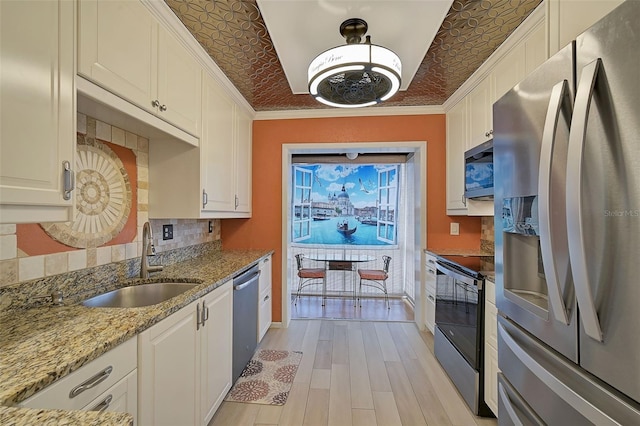 1026 Bird Bay Way Unit 276, Venice, FL 34285 - kitchen with appliances with stainless steel finishes, a sink, decorative backsplash, white cabinetry, and an ornate ceiling