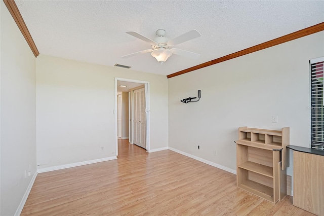 1026 Bird Bay Way Unit 276, Venice, FL 34285 - spare room with ceiling fan, light wood-type flooring, crown molding, a textured ceiling, and baseboards