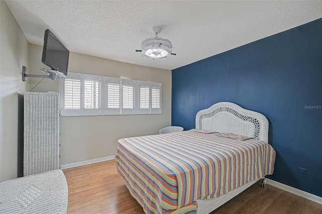 1026 Bird Bay Way Unit 276, Venice, FL 34285 - bedroom featuring wood finished floors, baseboards, a ceiling fan, and a textured ceiling