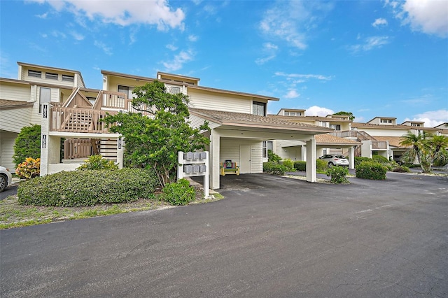1026 Bird Bay Way Unit 276, Venice, FL 34285 - view of building exterior featuring covered parking, stairs, and a residential view