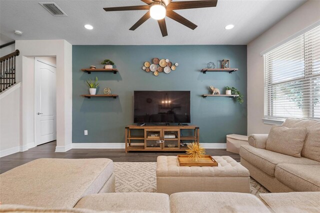 living room featuring a textured ceiling, ceiling fan, and dark hardwood / wood-style flooring