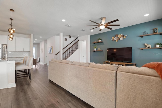 living room with dark wood-type flooring and ceiling fan