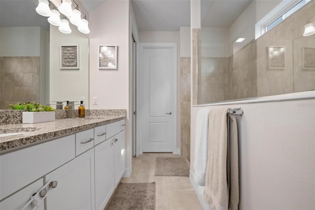 bathroom with vanity, tiled shower, and tile patterned floors