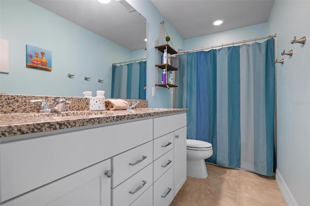 bathroom with tile patterned flooring, vanity, and toilet