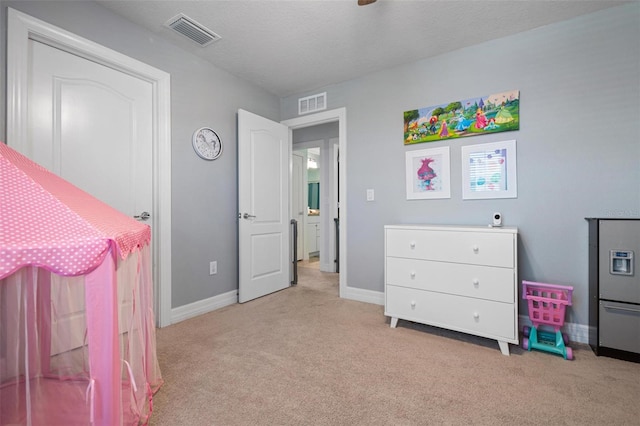 bedroom featuring a textured ceiling and light colored carpet