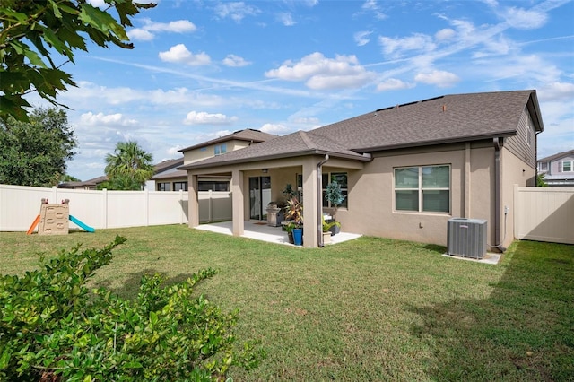 rear view of property with a yard, central AC, and a patio area