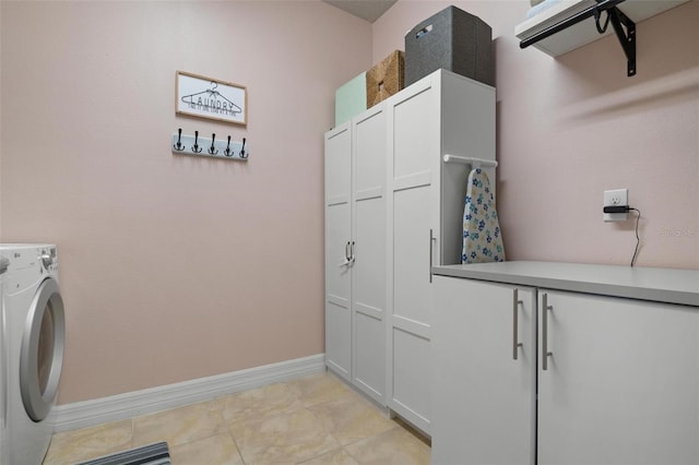 laundry area featuring cabinets, washer / clothes dryer, and light tile patterned floors