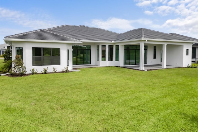 rear view of house with a patio and a yard