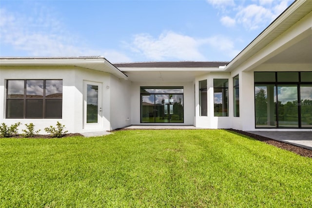 rear view of property with a lawn and a patio