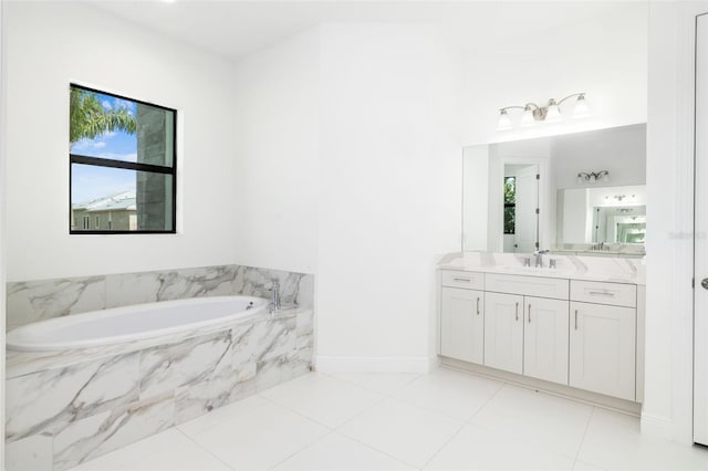 bathroom with tiled bath, vanity, and tile patterned floors