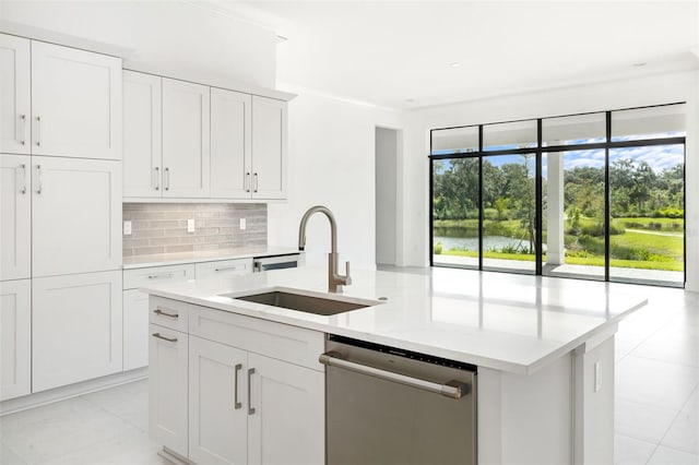 kitchen with an island with sink, sink, stainless steel dishwasher, backsplash, and white cabinetry