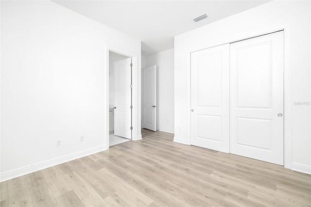 unfurnished bedroom featuring light hardwood / wood-style flooring and a closet