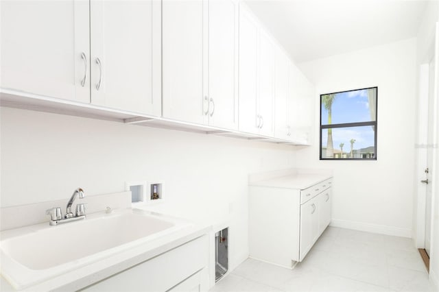 washroom with cabinets, hookup for a washing machine, light tile patterned floors, and sink