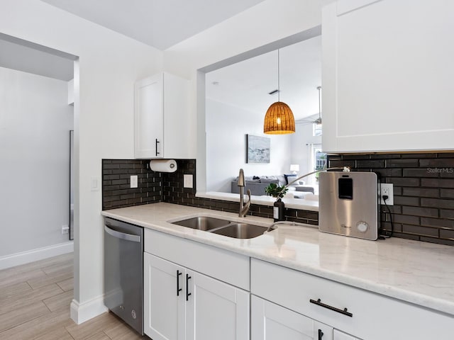 kitchen featuring white cabinets, light stone counters, sink, and stainless steel dishwasher