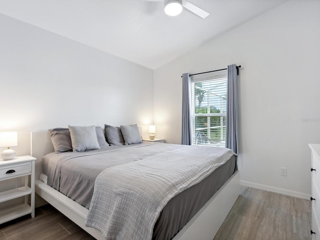 bedroom with ceiling fan, vaulted ceiling, and dark wood-type flooring