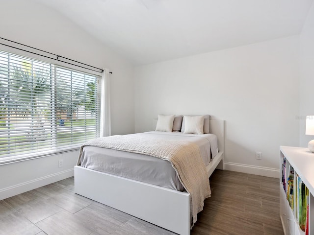 bedroom with wood-type flooring and lofted ceiling