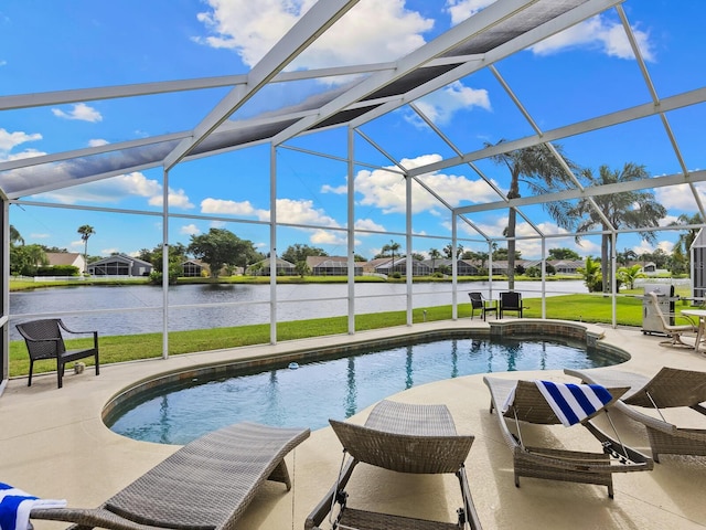 view of pool featuring a lawn, glass enclosure, a water view, and a patio area