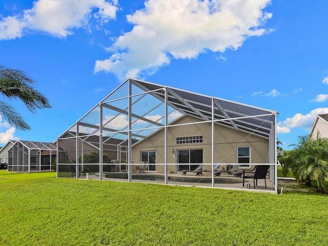 rear view of property featuring a lawn, a lanai, and a patio area