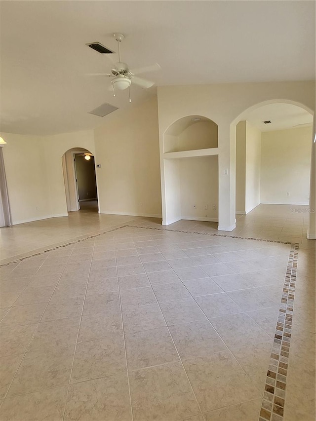 empty room featuring built in shelves, ceiling fan, and light tile patterned flooring