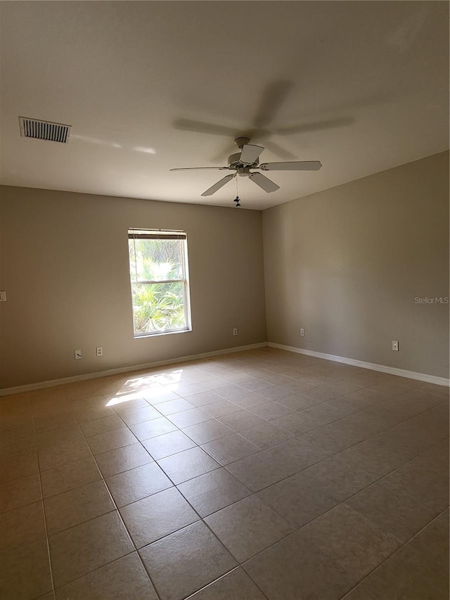 spare room with ceiling fan and light tile patterned floors